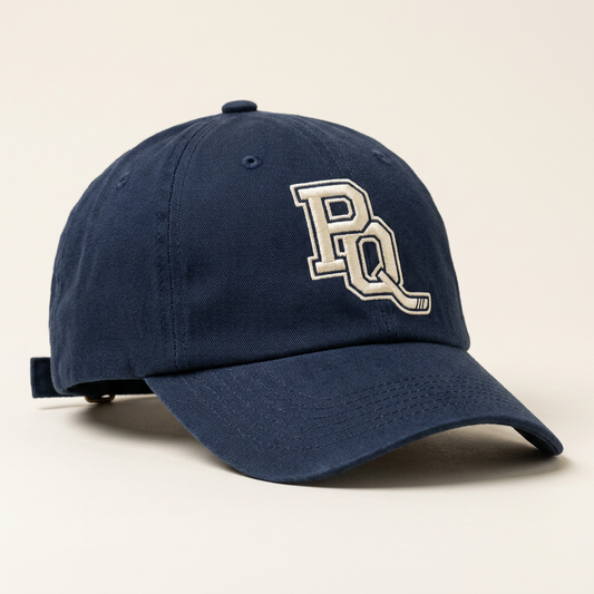 Navy unstructured dad hat with the PQ monogram embroidered in cream