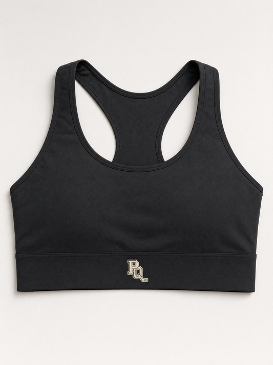 Black Puck Queens medium-support training top with wide flat underband and cream PQ monogram